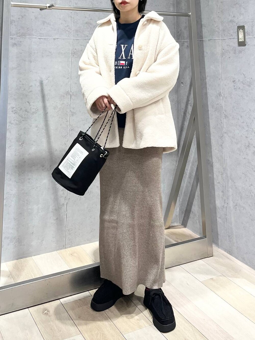 ブルー系のTシャツ/カットソー、ホワイト系のブルゾン、ブラック系のモカシン/デッキシューズを着用したレディースの秋コーディネートの1枚目の写真