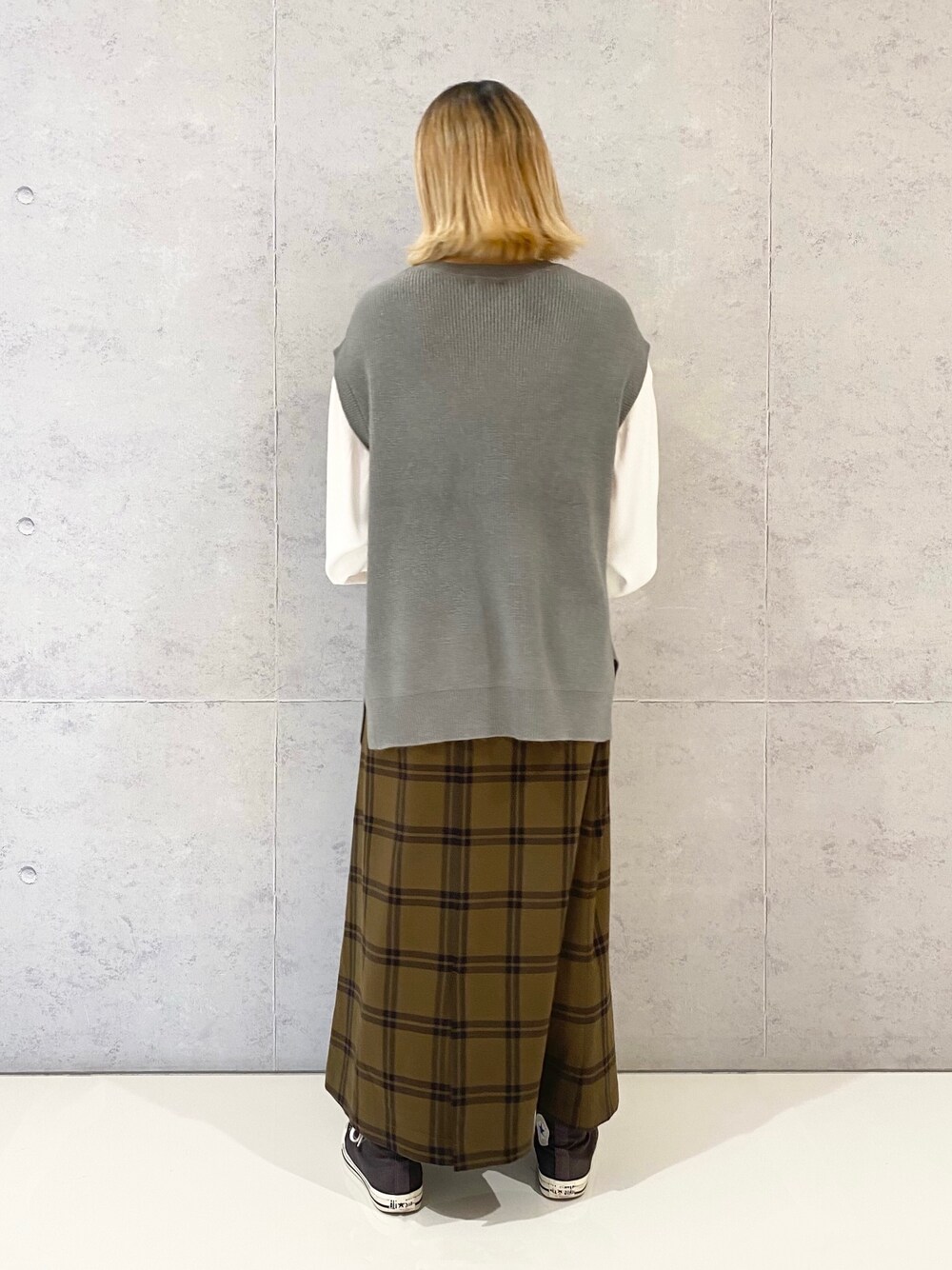 グレー系のニット/セーター、ブラウン系のスカート、グレー系のスニーカーを着用したレディースの冬コーディネートの4枚目の写真