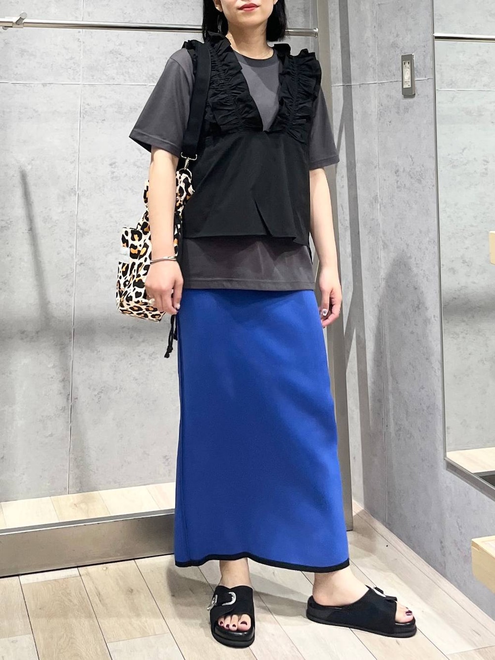 ブラック系のサンダル、ブラック系のベストを着用したレディースの夏コーディネートの1枚目の写真