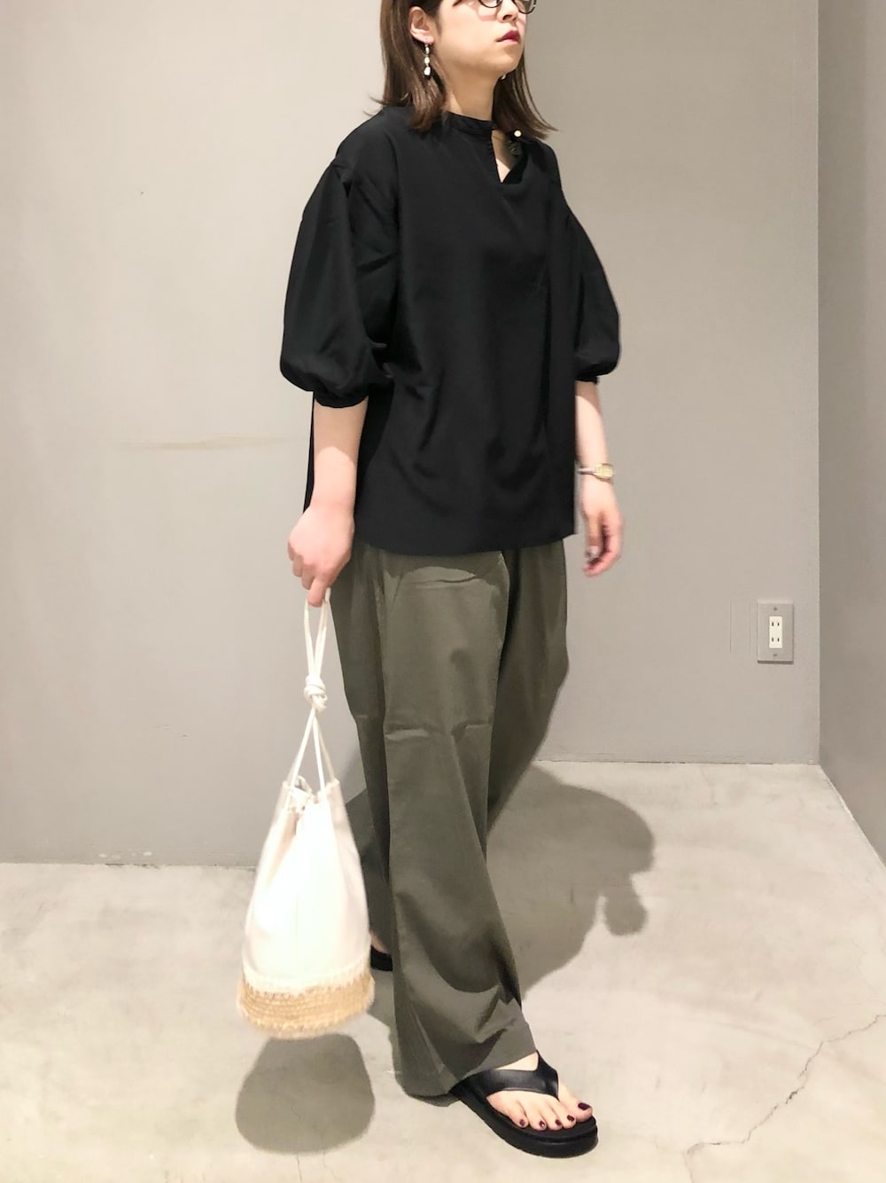 ブラック系のシャツ/ブラウス、グリーン系のその他パンツ、ブラック系のサンダルを着用したレディースの春コーディネートの2枚目の写真