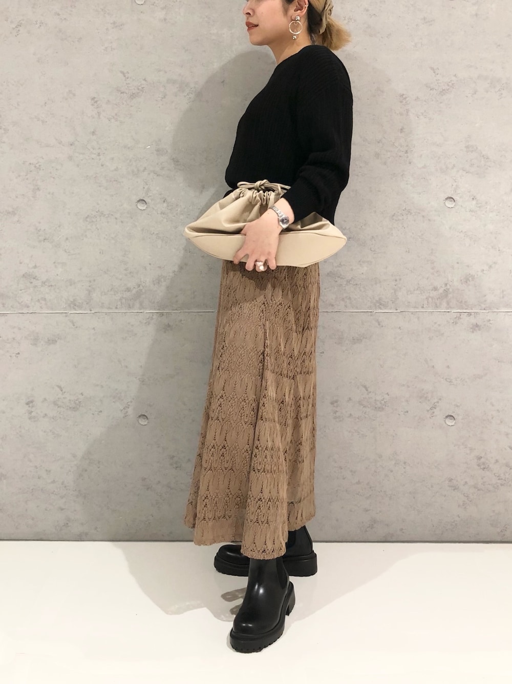 ブラック系のニット/セーター、ブラウン系のスカート、ブラック系のブーツを着用したレディースの冬コーディネートの2枚目の写真