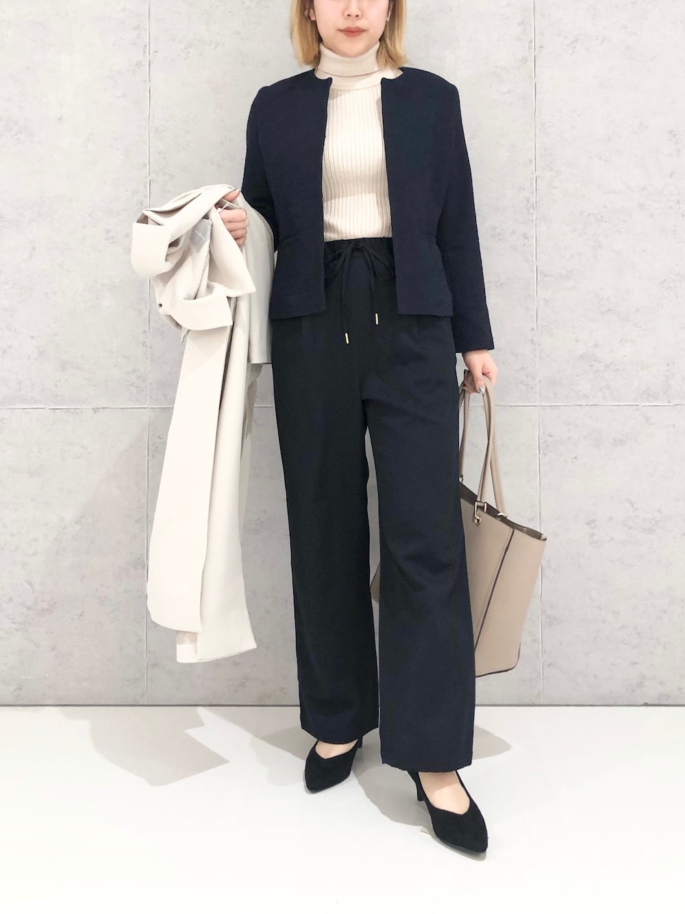 ホワイト系のニット/セーター、ベージュ系のトレンチコート、ブルー系のその他パンツを着用したレディースの冬コーディネートの2枚目の写真