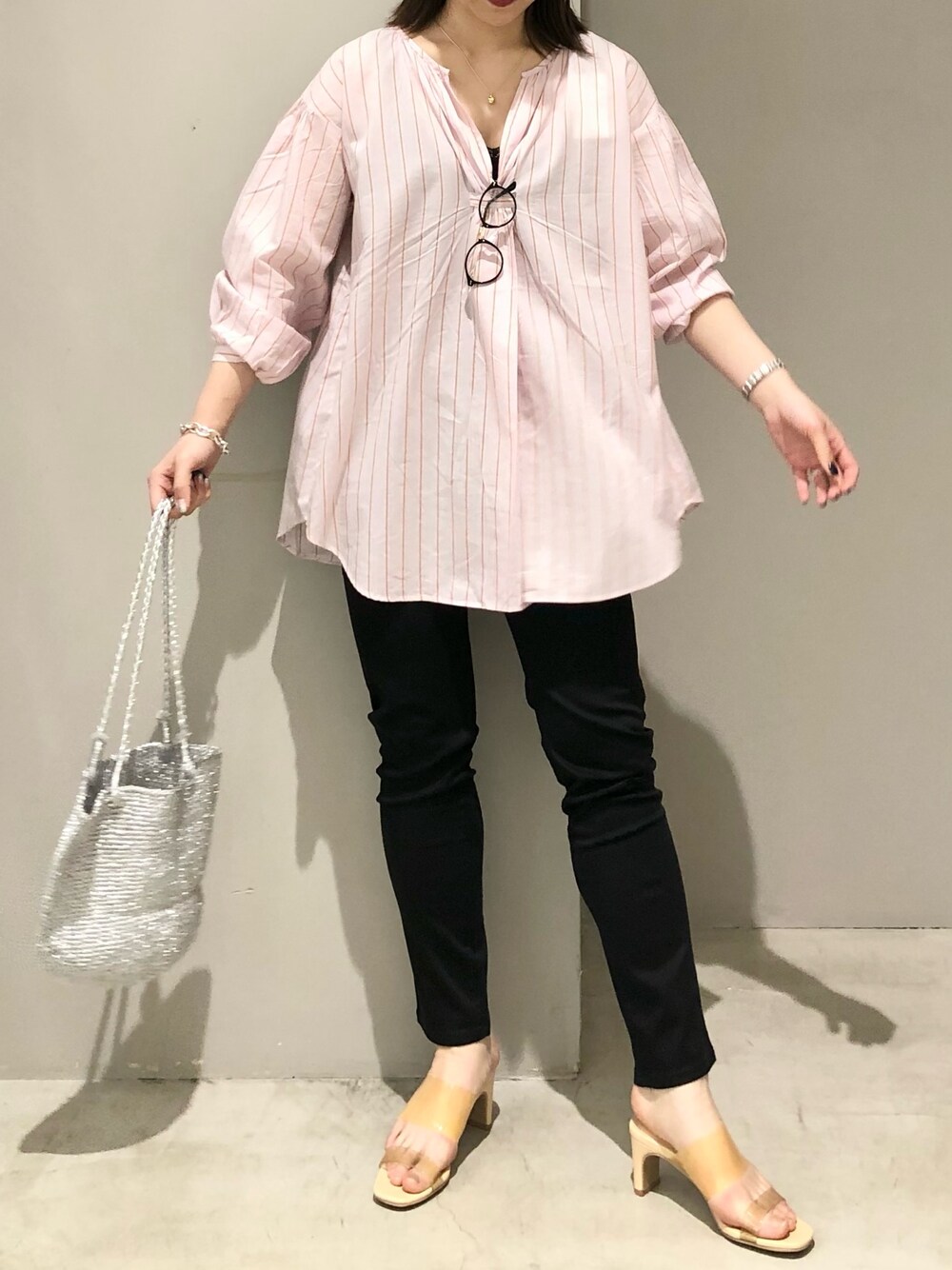 ブラック系のパンツ、イエロー系のサンダル、シルバー系のショルダーバッグを着用したレディースの春コーディネートの2枚目の写真