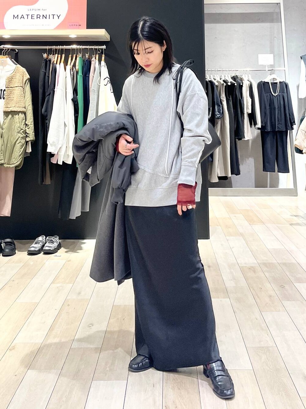 ブラック系のローファー、ブラック系のスカート、ブラック系のTシャツ/カットソーを着用したレディースの冬コーディネートの1枚目の写真