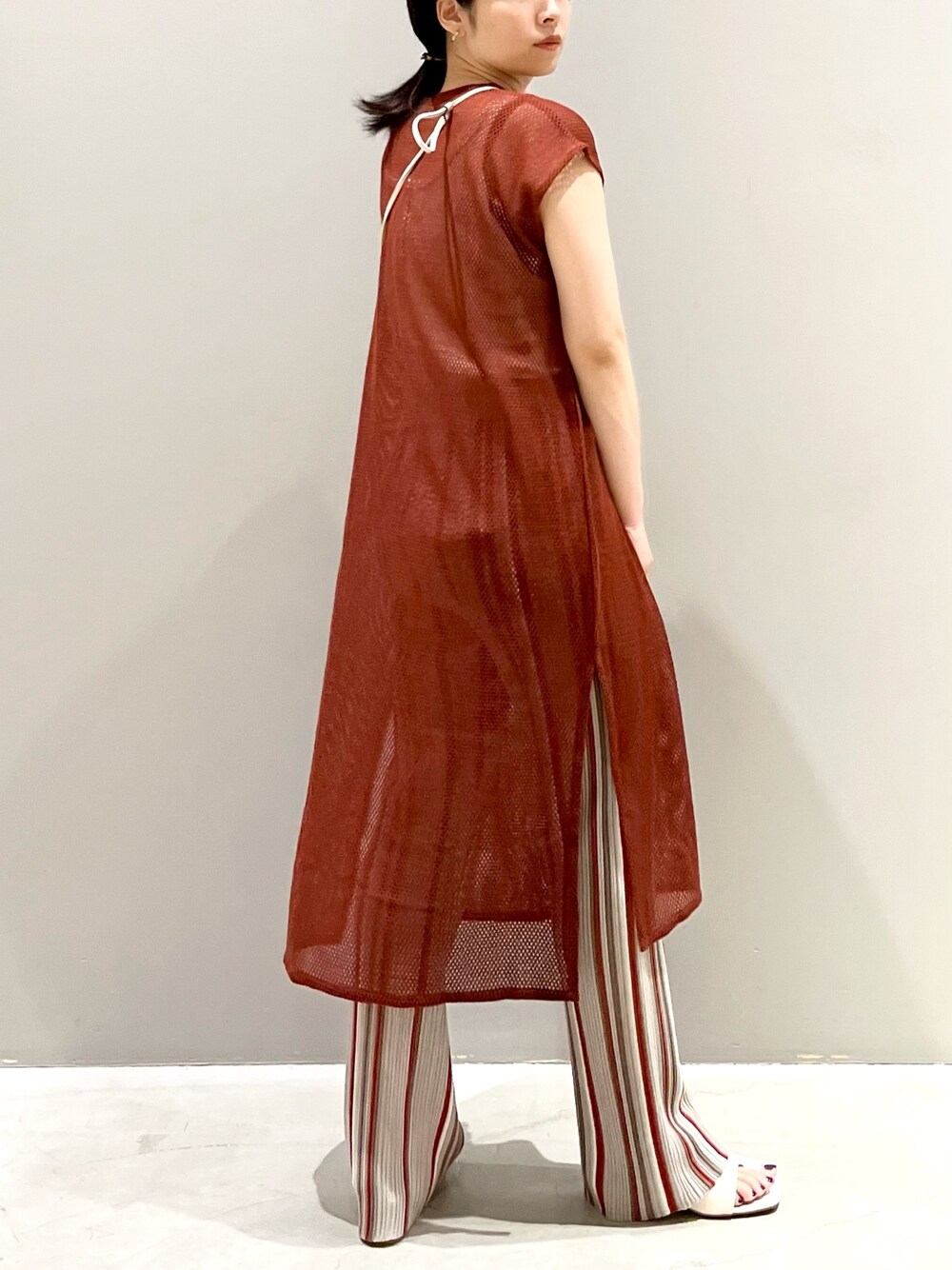 ブラウン系のワンピース、グレー系のパンツ、ホワイト系のサンダルを着用したレディースの秋コーディネートの4枚目の写真