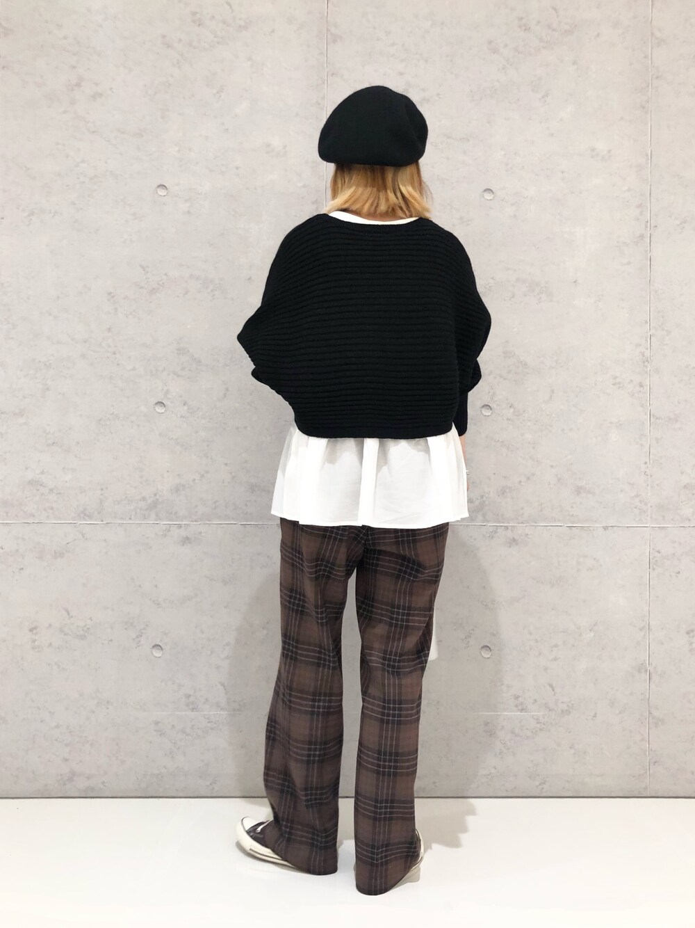 グレー系のスニーカー、シルバー系のショルダーバッグ、ブラック系のニット/セーターを着用したレディースの冬コーディネートの3枚目の写真