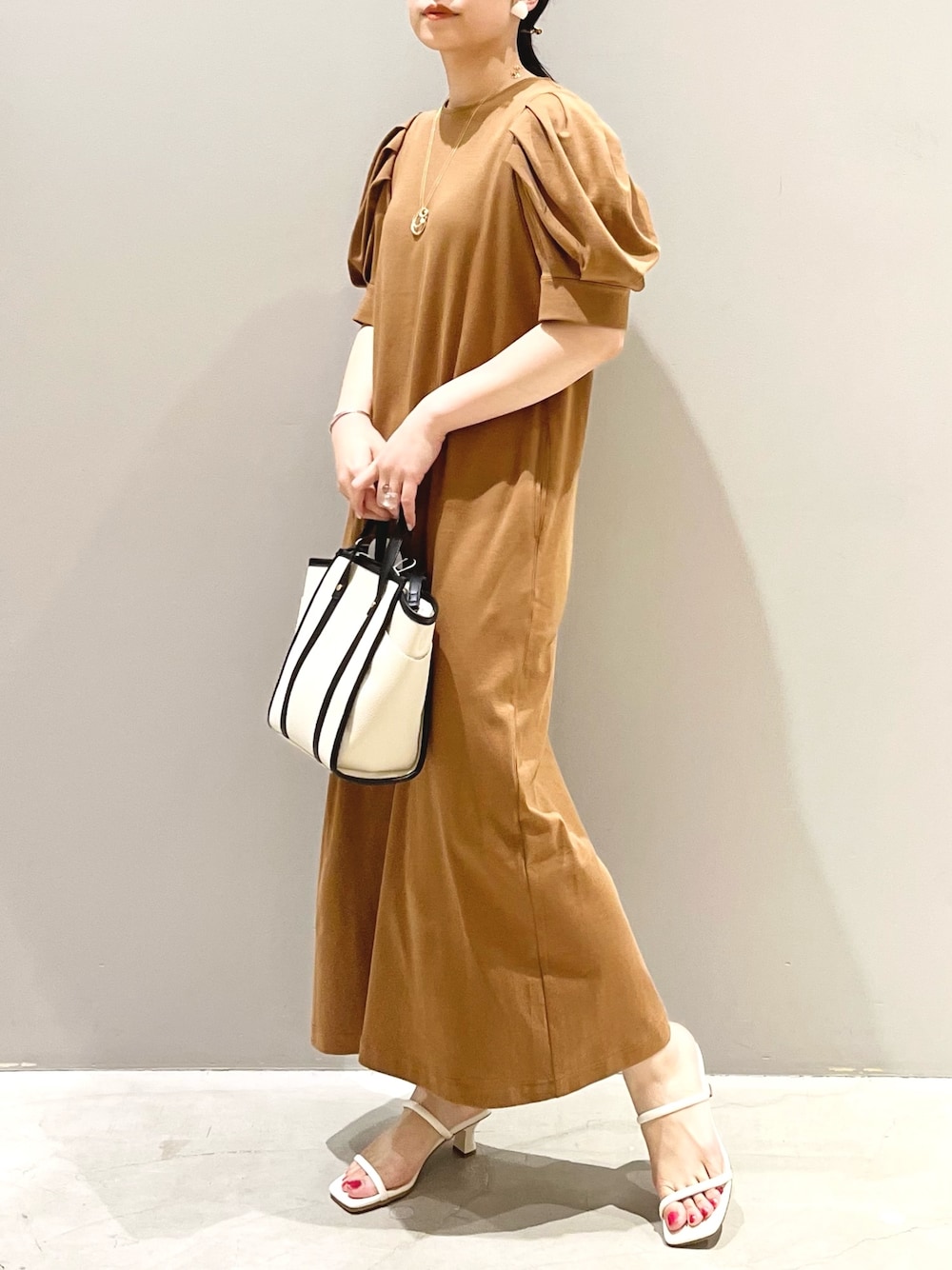 ブラウン系のワンピース/ドレス、ホワイト系のバッグ、ホワイト系のサンダルを着用したレディースの夏コーディネートの1枚目の写真