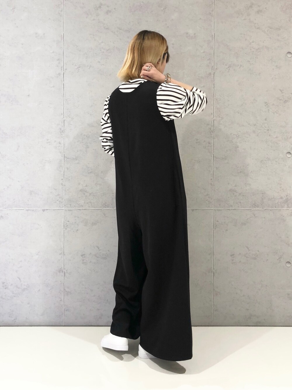 ブラック系のつなぎ/オールインワン、ホワイト系のTシャツ/カットソー、ホワイト系のスニーカーを着用したレディースの冬コーディネートの2枚目の写真