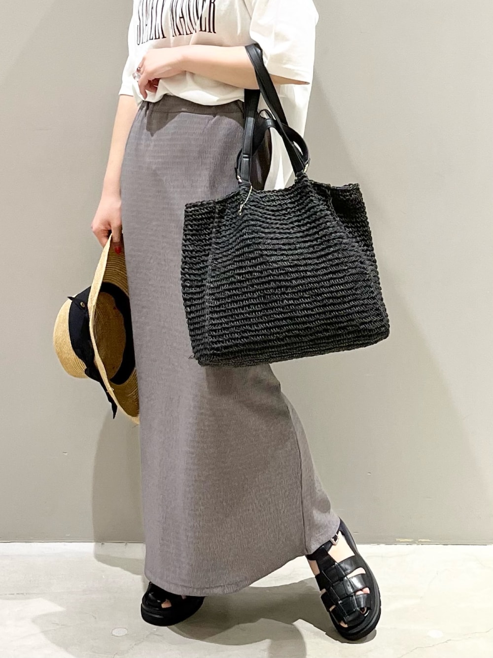 ブラウン系のスカート、ブラック系のサンダル、ホワイト系のTシャツ/カットソーを着用したレディースの夏コーディネートの3枚目の写真