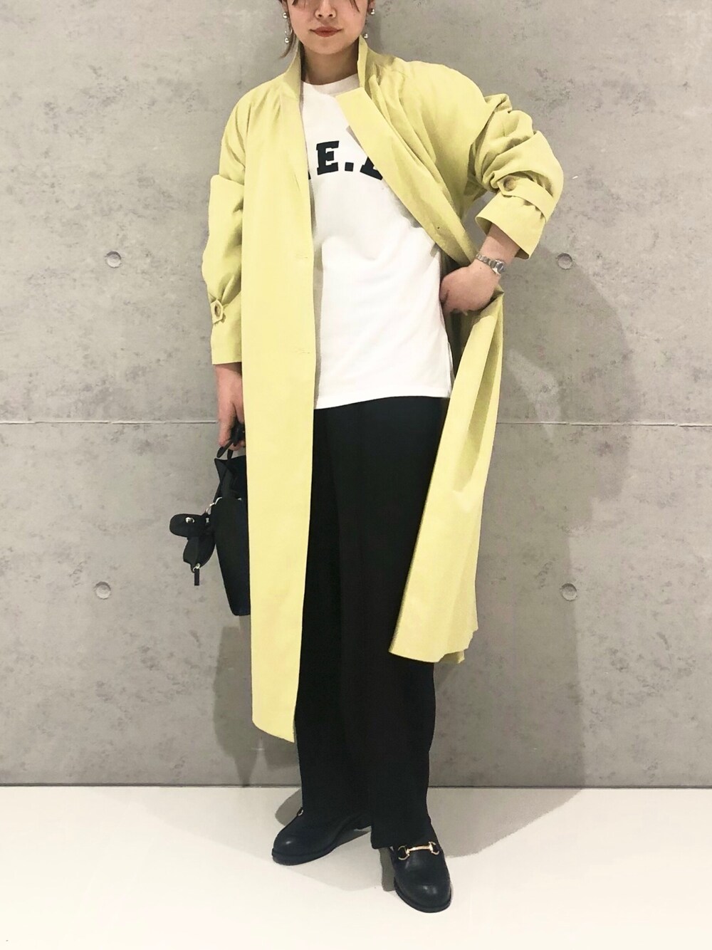 ブラック系のショルダーバッグ、ブラック系のローファー、ホワイト系のTシャツ/カットソーを着用したレディースの春コーディネートの3枚目の写真
