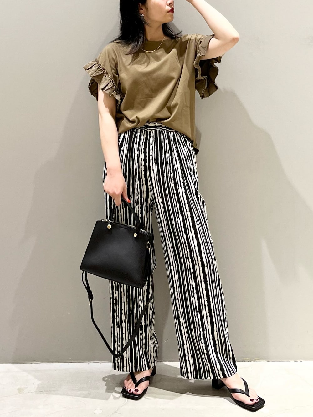 グリーン系のTシャツ/カットソー、ブラック系のサンダル、ブラック系のショルダーバッグを着用したレディースの夏コーディネートの1枚目の写真