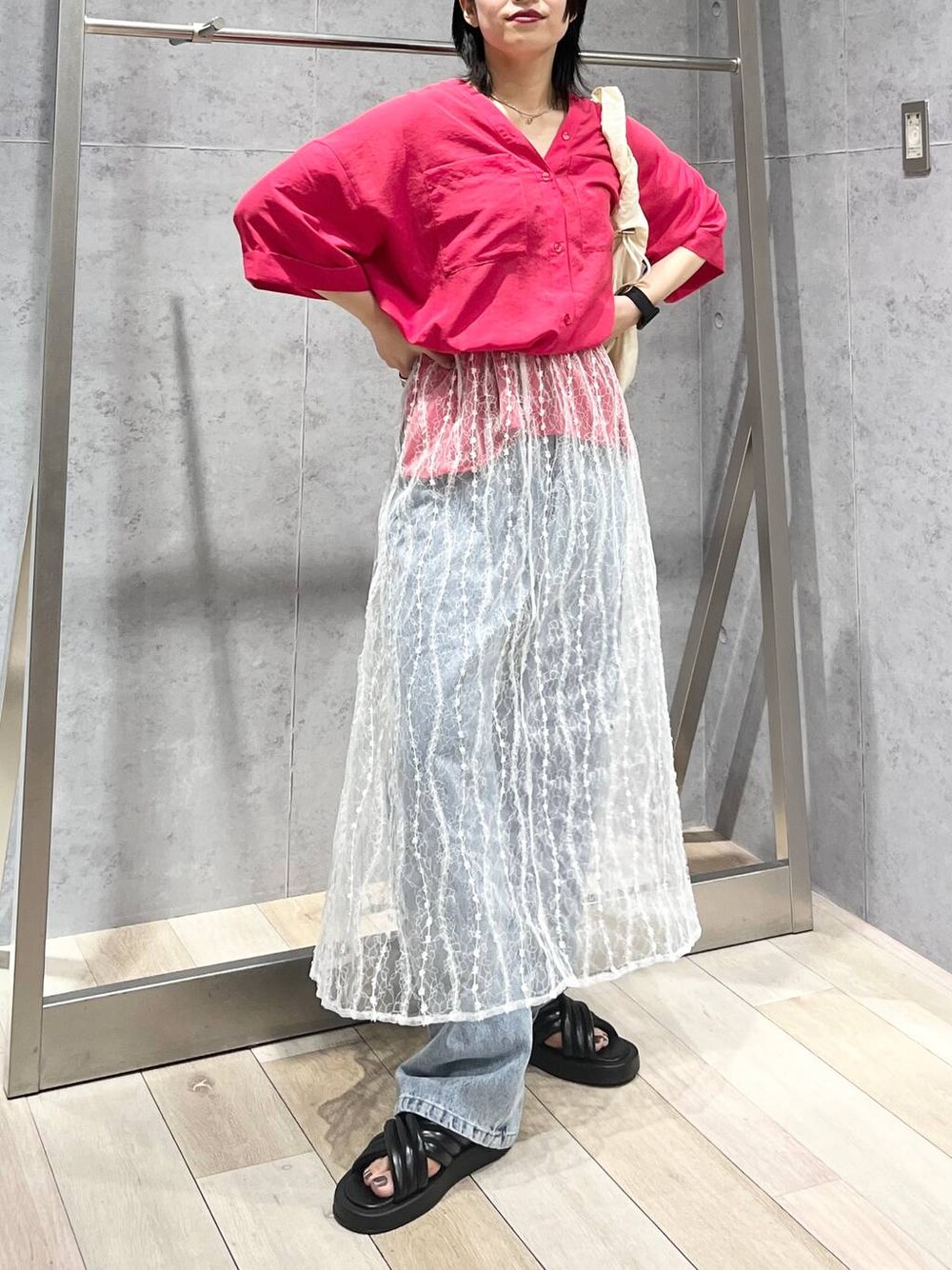 ブラック系のサンダル、ブルー系のデニムパンツ、ホワイト系のスカートを着用したレディースの夏コーディネートの1枚目の写真