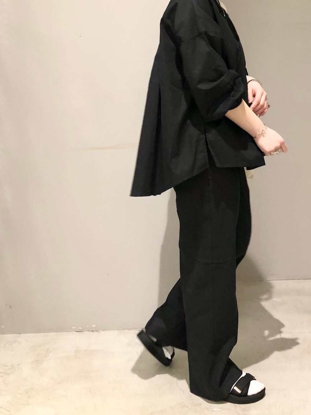 ブラック系のサンダル、ブラック系のその他パンツ、ホワイト系のトートバッグを着用したレディースの春コーディネートの2枚目の写真