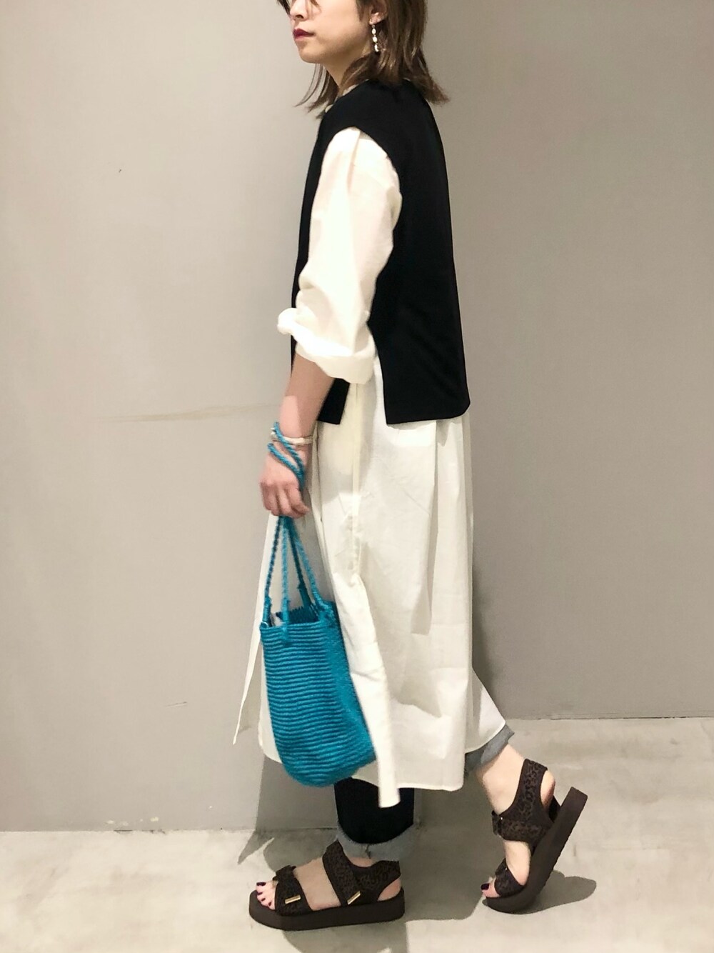 グリーン系のショルダーバッグ、ホワイト系のワンピース、その他のサンダルを着用したレディースの夏コーディネートの2枚目の写真