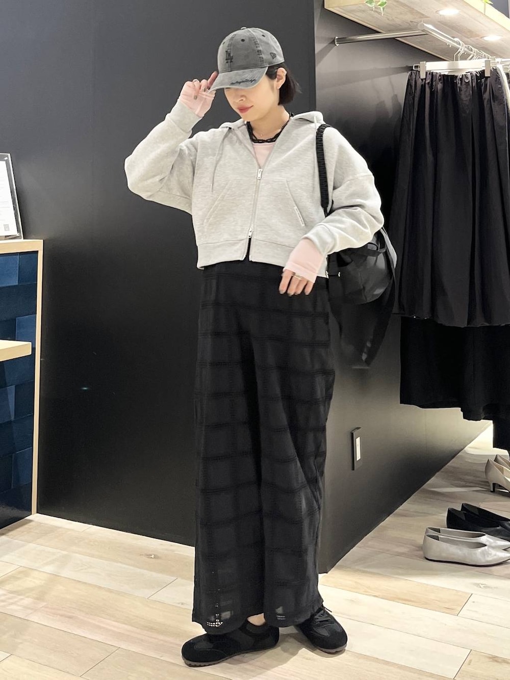 ピンク系のTシャツ/カットソー、ブラック系のショルダーバッグ、ブラック系のスニーカーを着用したレディースの春コーディネートの1枚目の写真