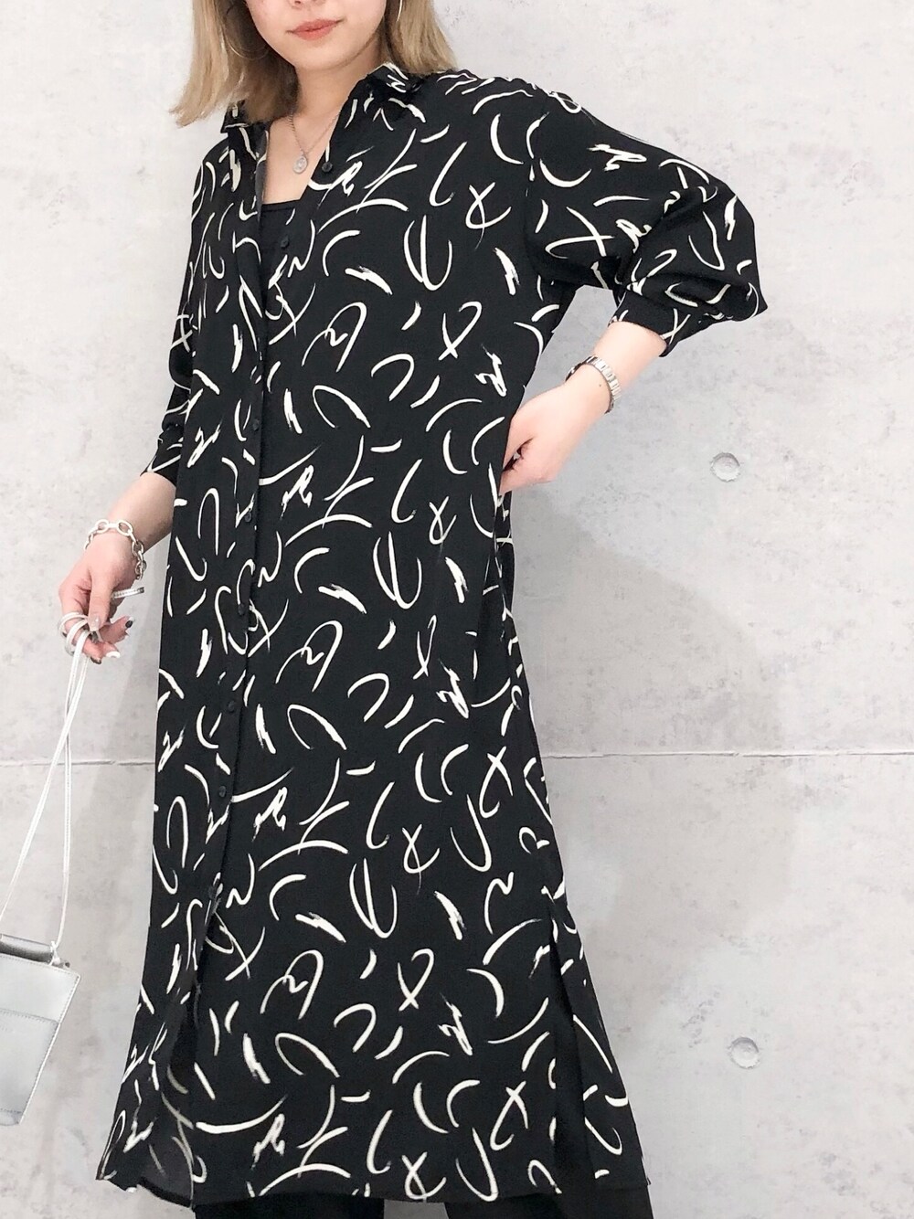 ブラック系のワンピース、ベージュ系のパンプス、シルバー系のショルダーバッグを着用したレディースの冬コーディネートの2枚目の写真