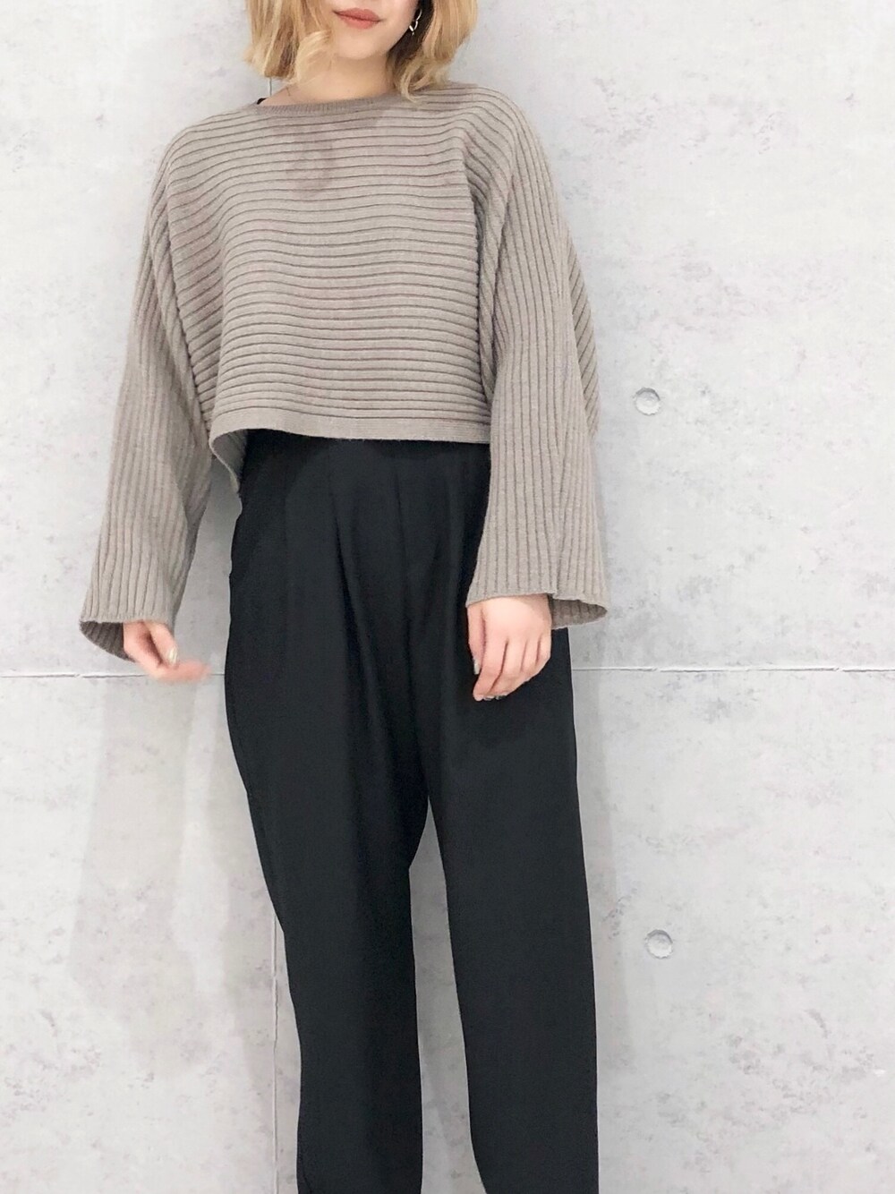 ブラック系のスラックス、シルバー系のパンプス、ベージュ系のニット/セーターを着用したレディースの冬コーディネートの4枚目の写真