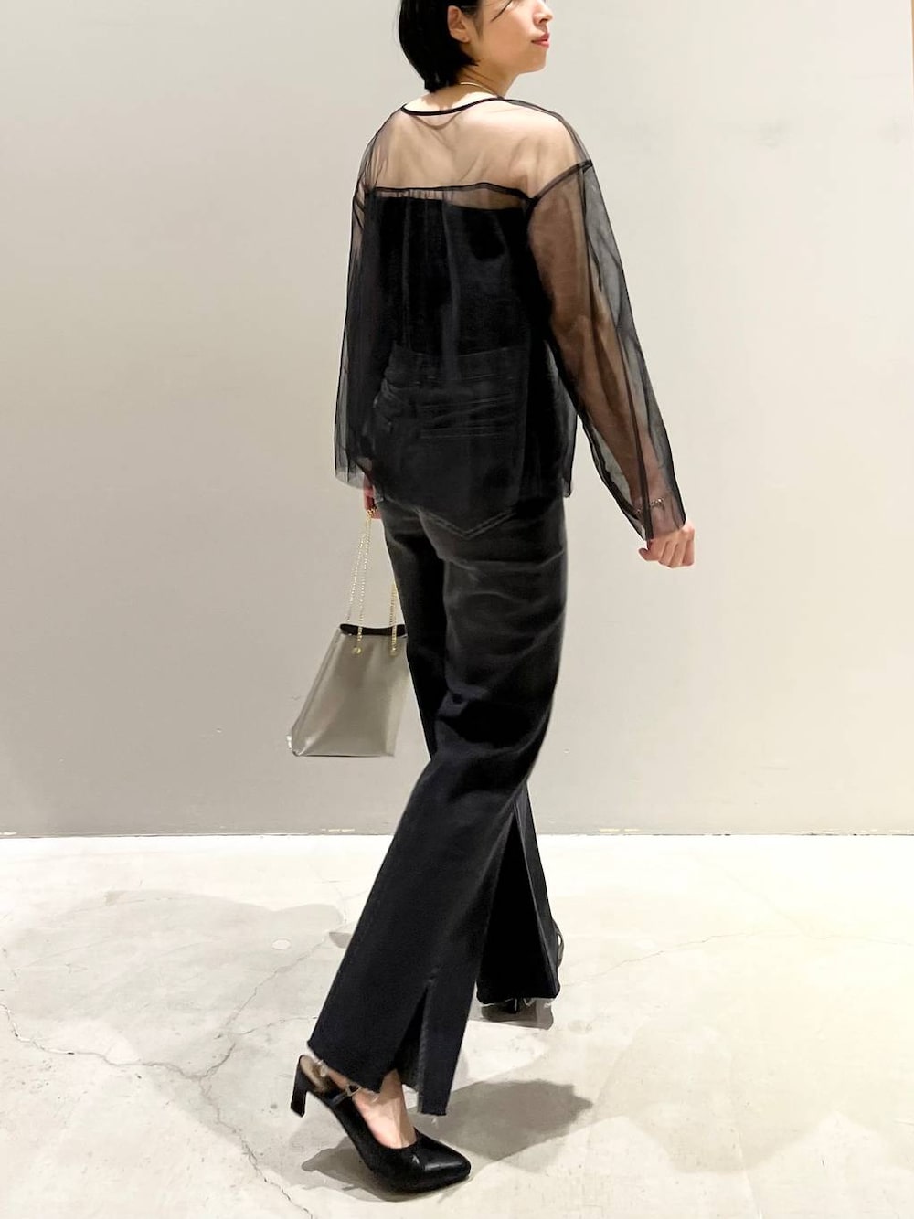 ブラック系のチューブトップ、ブラック系のTシャツ/カットソー、ブラック系のデニムパンツを着用したレディースの秋コーディネートの1枚目の写真