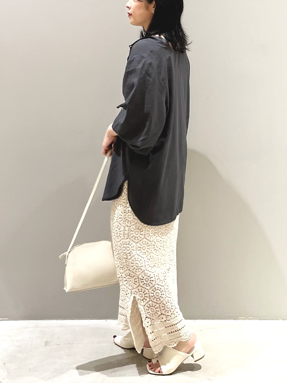 ホワイト系のスカート、ホワイト系のサンダル、ホワイト系のショルダーバッグを着用したレディースの夏コーディネートの2枚目の写真