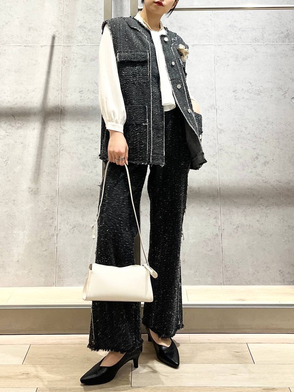 ホワイト系のシャツ/ブラウス、ブラック系のパンプス、ホワイト系のショルダーバッグを着用したレディースの冬コーディネートの1枚目の写真