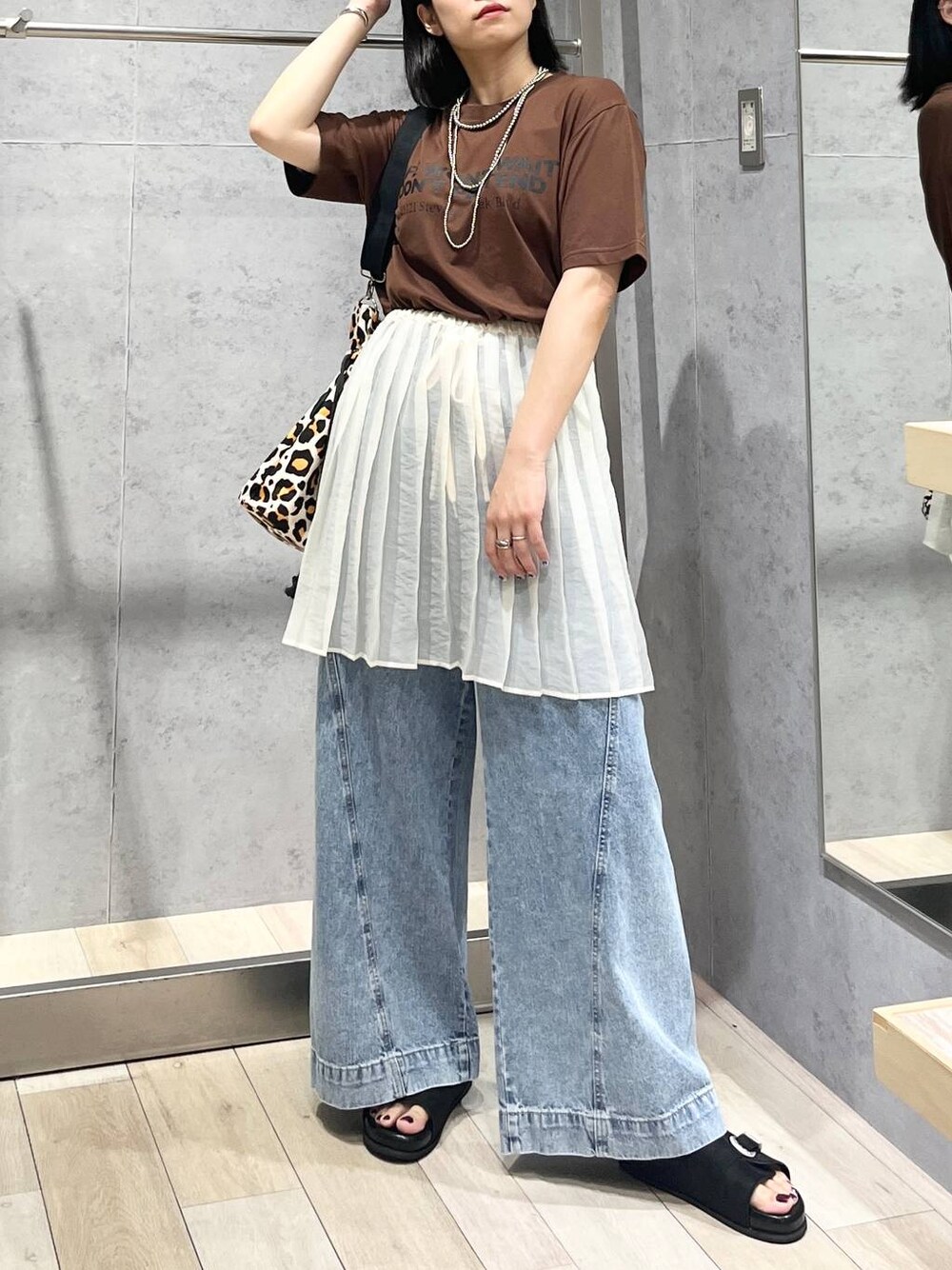 ブルー系のデニムパンツ、ブラック系のサンダル、シルバー系のネックレスを着用したレディースの夏コーディネートの1枚目の写真