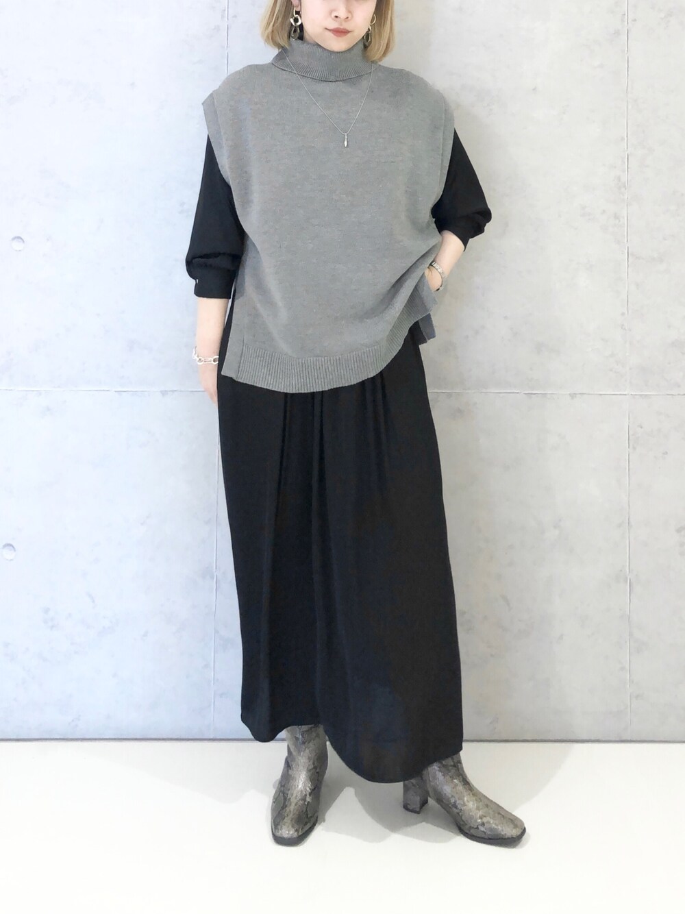 ブラック系のワンピース、その他のブーツ、グレー系のベストを着用したレディースの冬コーディネートの2枚目の写真