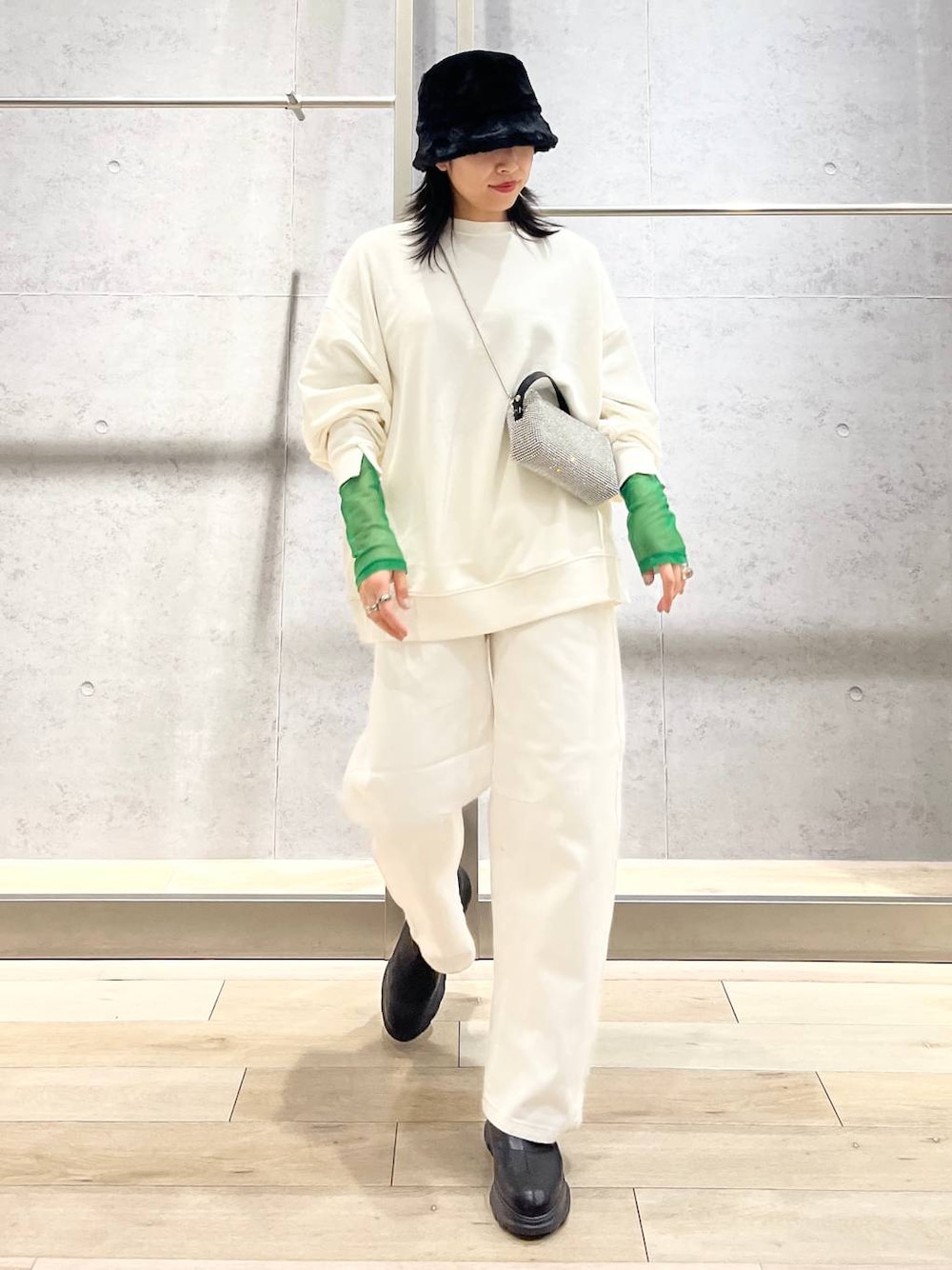 ブラック系のTシャツ/カットソー、ホワイト系のスウェット、ブラック系のブーツを着用したレディースの冬コーディネートの1枚目の写真