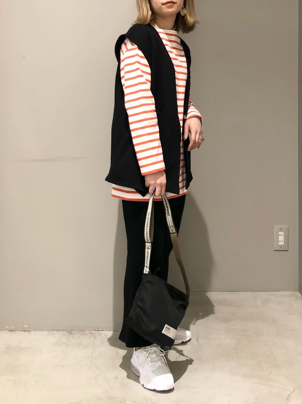 ホワイト系のシューズ、ブラック系のショルダーバッグ、ブラック系のスカートを着用したレディースの春コーディネートの3枚目の写真