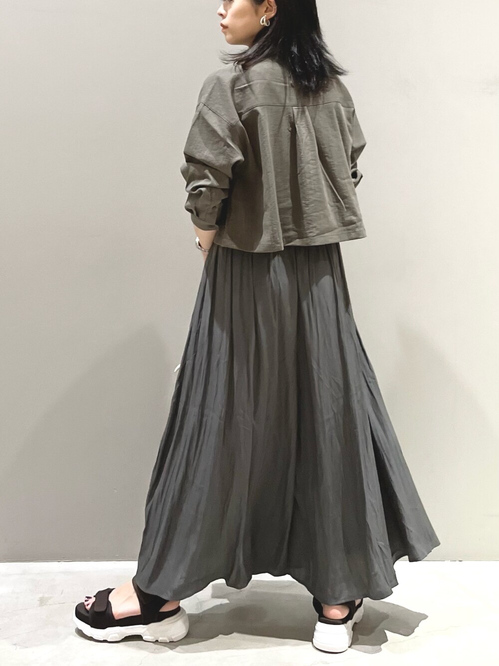 ホワイト系のショルダーバッグ、ブラウン系のサンダル、グレー系のその他パンツを着用したレディースの夏コーディネートの2枚目の写真