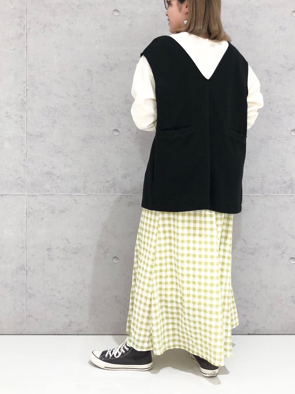 ホワイト系のスウェット、ブラック系のトップス、イエロー系のスカートを着用したレディースの冬コーディネートの3枚目の写真