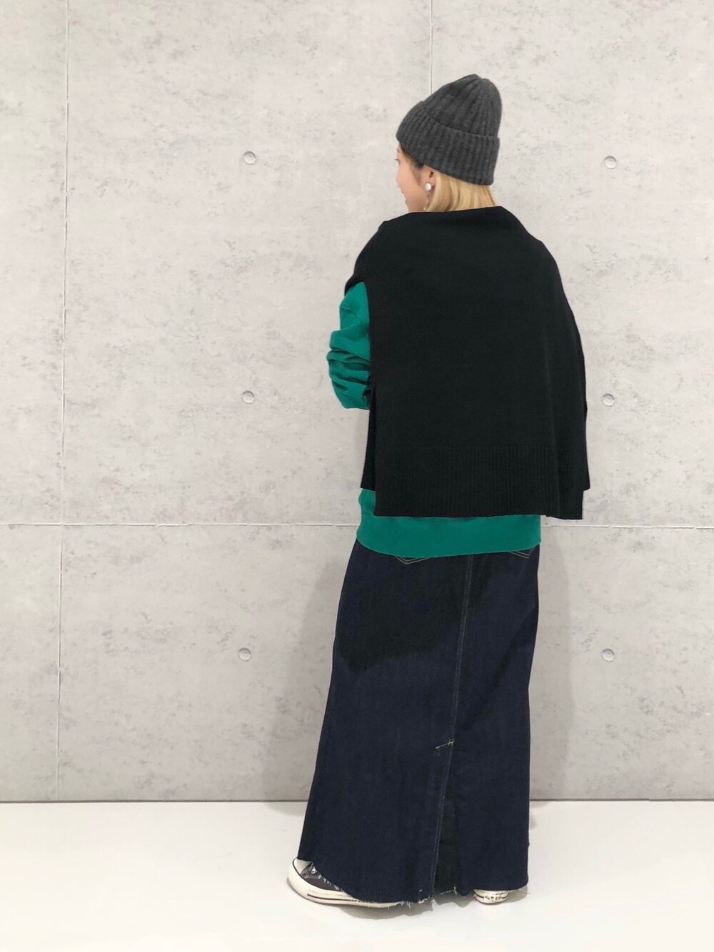 グリーン系のスウェット、ブラック系のカーディガン/ボレロ、ブラック系のスカートを着用したレディースの冬コーディネートの4枚目の写真