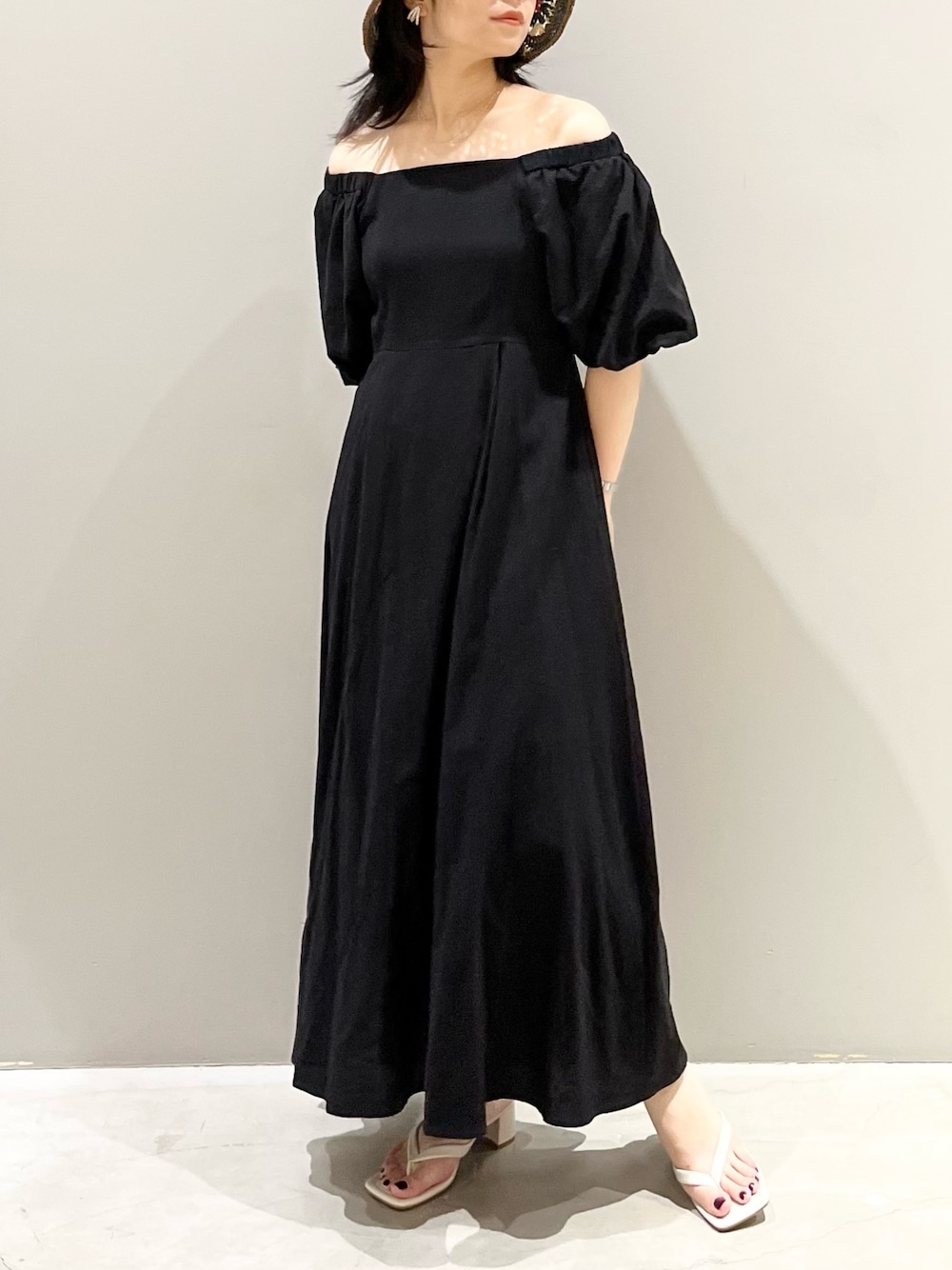 ホワイト系のサンダル、ブラック系のワンピース、その他のハットを着用したレディースの夏コーディネートの2枚目の写真