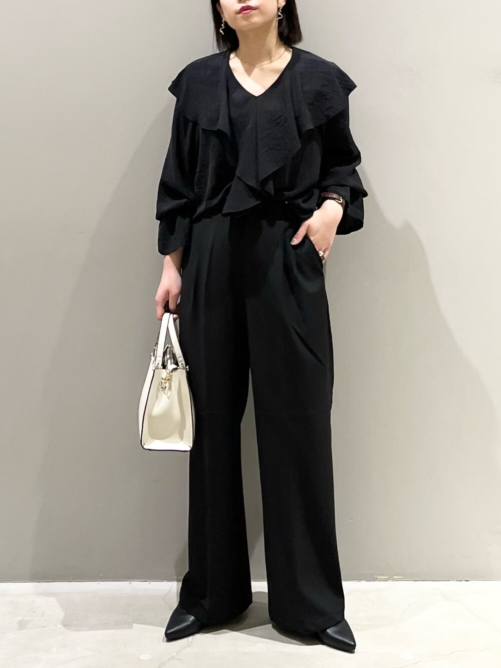 ブラック系のシャツ/ブラウス、ブラック系のバッグ、ブラック系のパンツを着用したレディースの春コーディネートの1枚目の写真