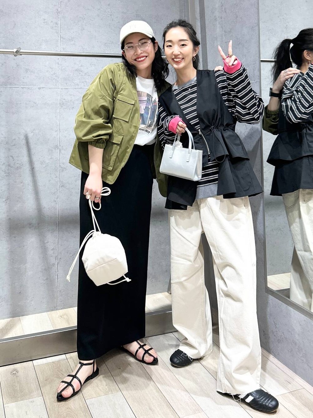 ブラック系のスカート、ホワイト系のショルダーバッグ、ブラック系のサンダルを着用したレディースの春コーディネートの1枚目の写真