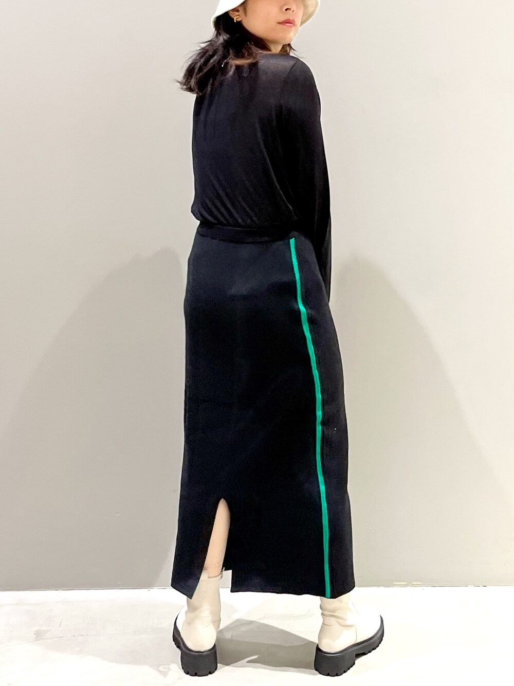 ブラック系のスカート、ホワイト系のブーツ、ブラック系のTシャツ/カットソーを着用したレディースの秋コーディネートの3枚目の写真