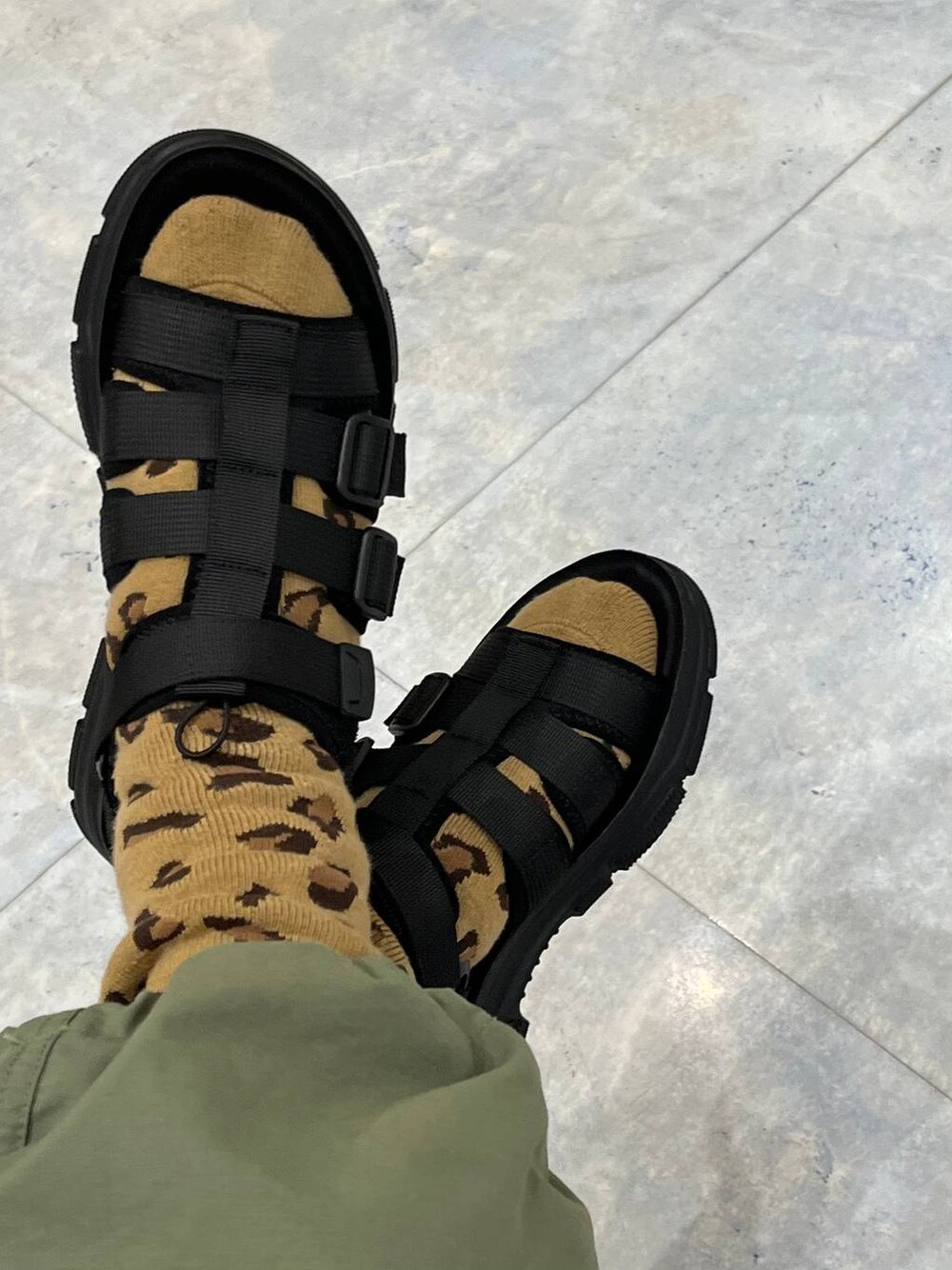 グリーン系のカーゴパンツ、ブラック系のサンダルを着用したレディースの春コーディネートの1枚目の写真