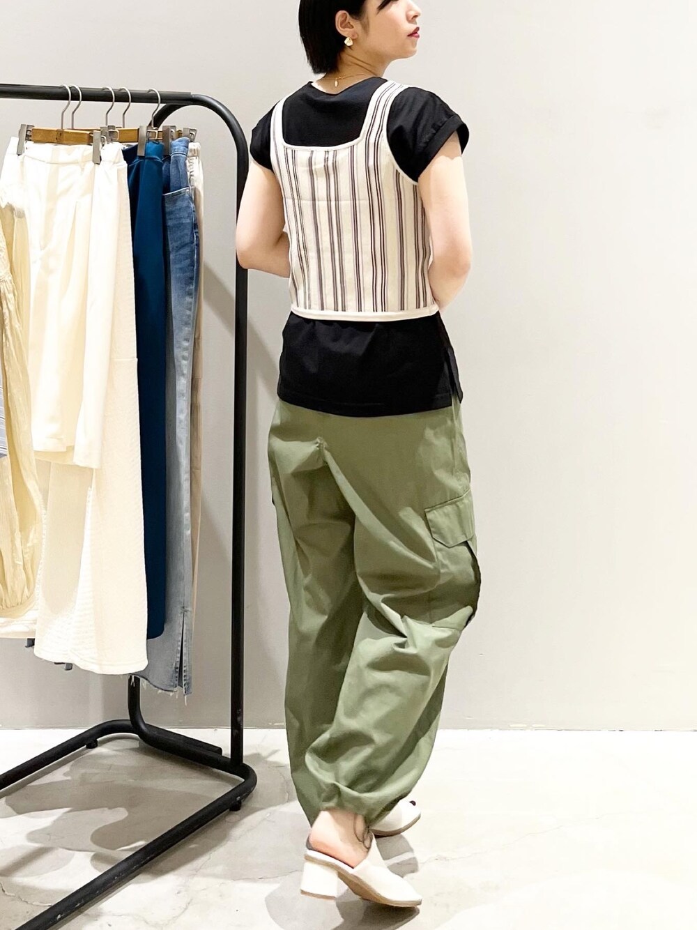 ベージュ系のタンクトップ、ブラック系のTシャツ/カットソー、グリーン系のパンツを着用したレディースの夏コーディネートの1枚目の写真