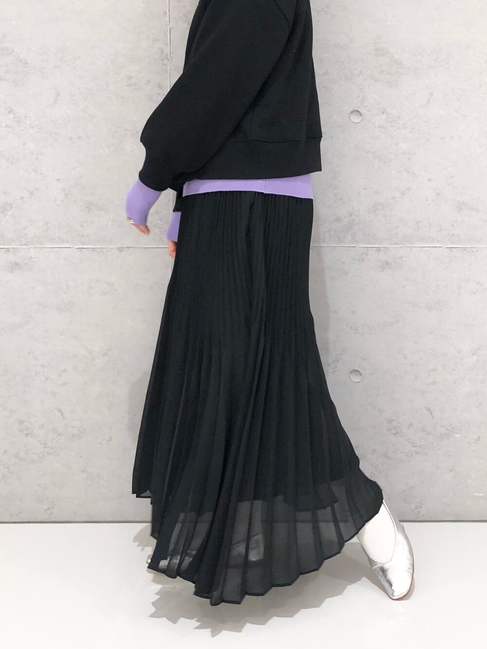 ブラック系のスカート、シルバー系のパンプス、パープル系のニット/セーターを着用したレディースの冬コーディネートの2枚目の写真