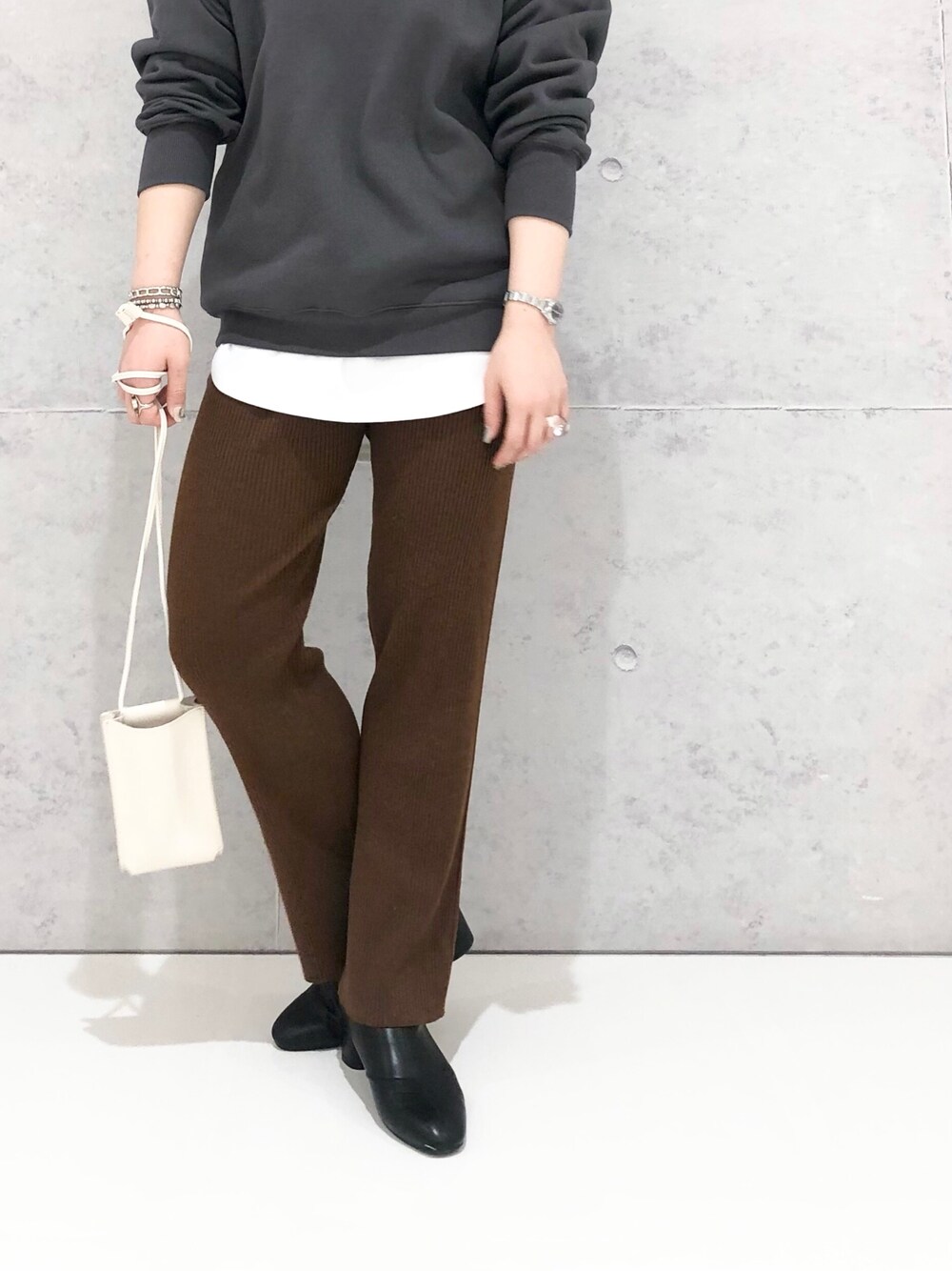 ホワイト系のTシャツ/カットソー、グレー系のスウェット、ブラック系のブーツを着用したレディースの冬コーディネートの3枚目の写真