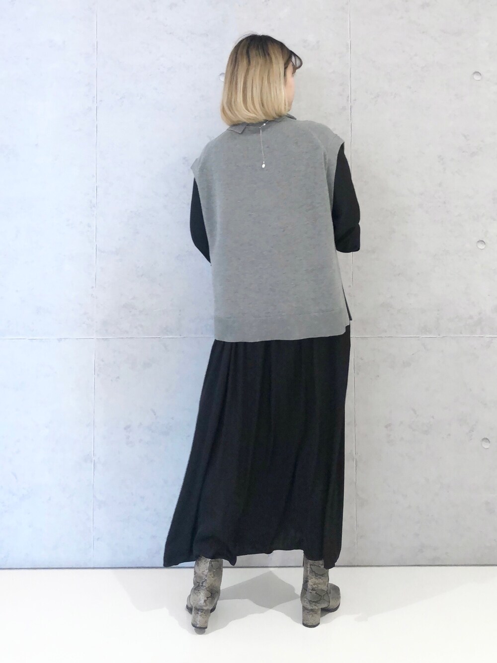 ブラック系のワンピース、その他のブーツ、グレー系のベストを着用したレディースの冬コーディネートの4枚目の写真