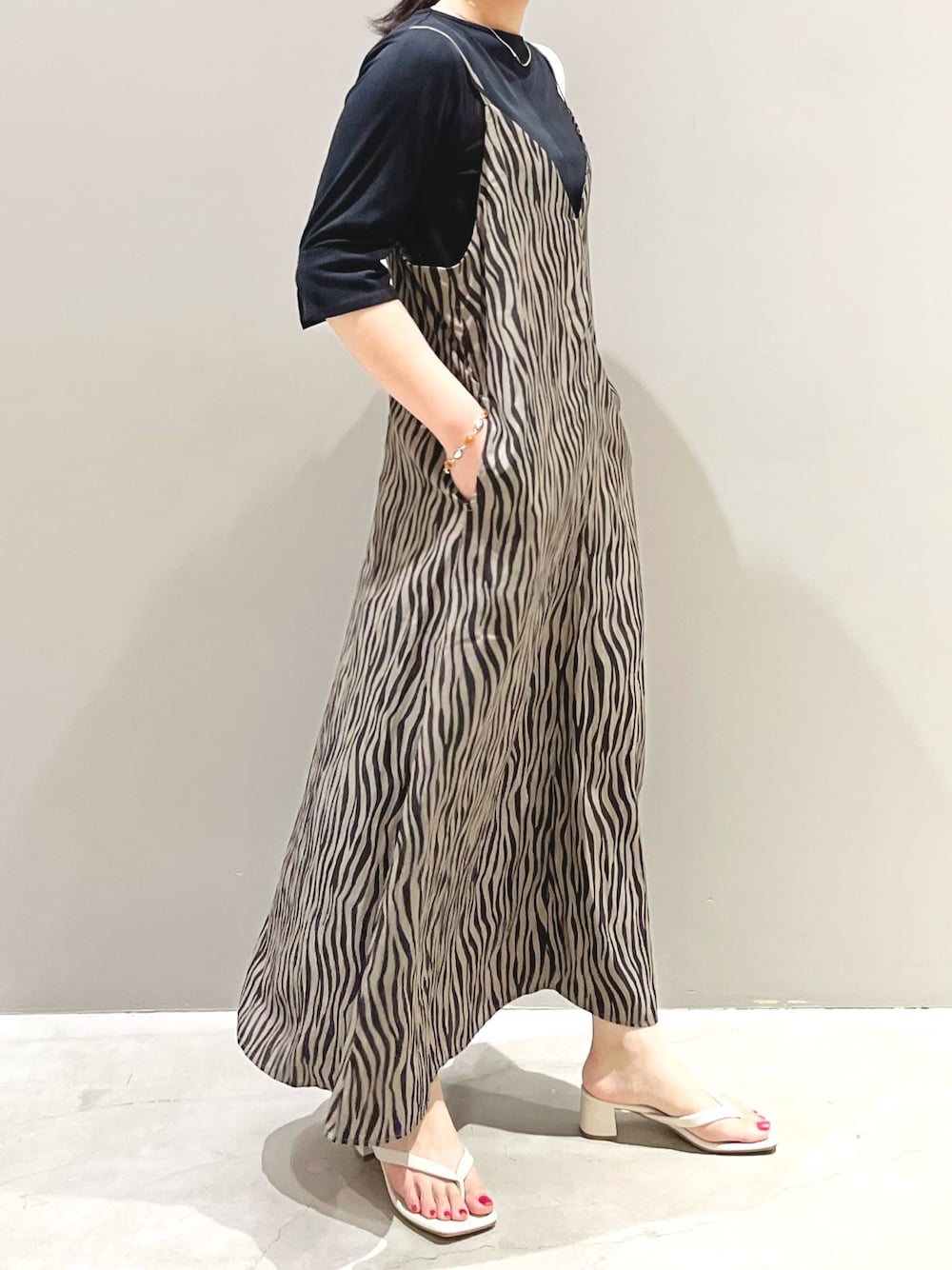 ホワイト系のサンダル、ホワイト系のショルダーバッグ、ブラック系のワンピース/ドレスを着用したレディースの秋コーディネートの3枚目の写真