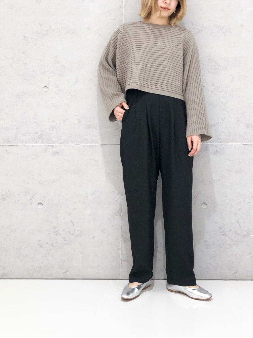 ブラック系のスラックス、シルバー系のパンプス、ベージュ系のニット/セーターを着用したレディースの冬コーディネートの2枚目の写真