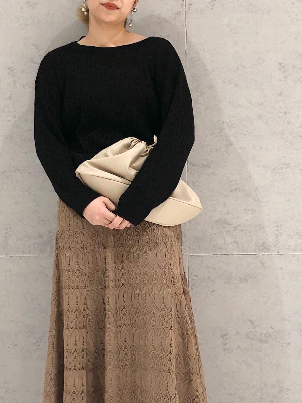 ブラック系のニット/セーター、ブラウン系のスカート、ブラック系のブーツを着用したレディースの冬コーディネートの3枚目の写真