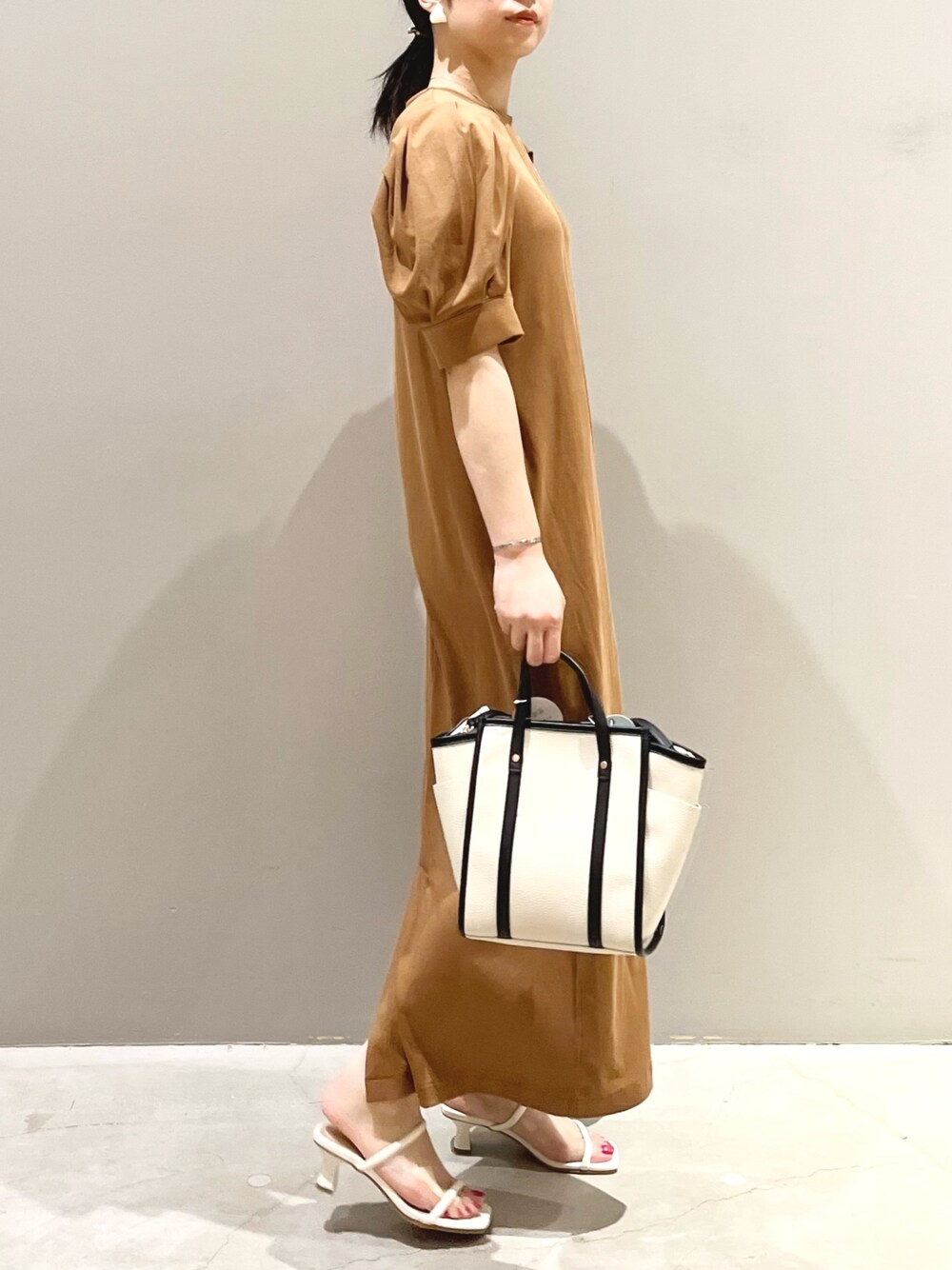 ブラウン系のワンピース/ドレス、ホワイト系のバッグ、ホワイト系のサンダルを着用したレディースの夏コーディネートの2枚目の写真