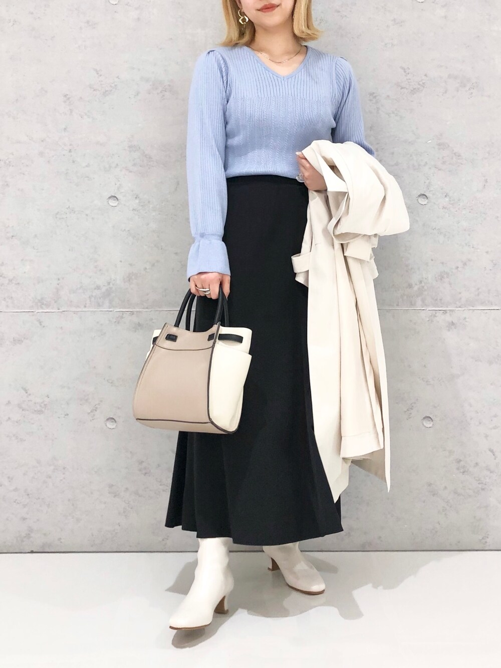 ブラウン系のショルダーバッグ、ホワイト系のジャケット/アウター、ブラック系のスカートを着用したレディースの冬コーディネートの3枚目の写真