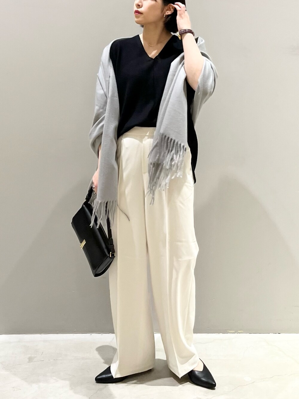 ブラック系のニット/セーター、ブラック系のハンドバッグ、ブラック系のパンツを着用したレディースの冬コーディネートの1枚目の写真