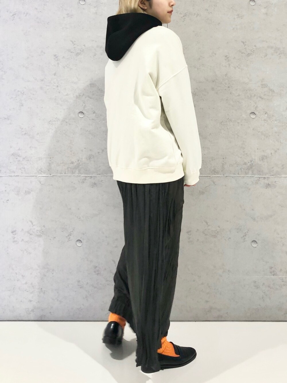 ホワイト系のスウェット、ブラック系のパーカー、グレー系のその他パンツを着用したレディースの冬コーディネートの2枚目の写真