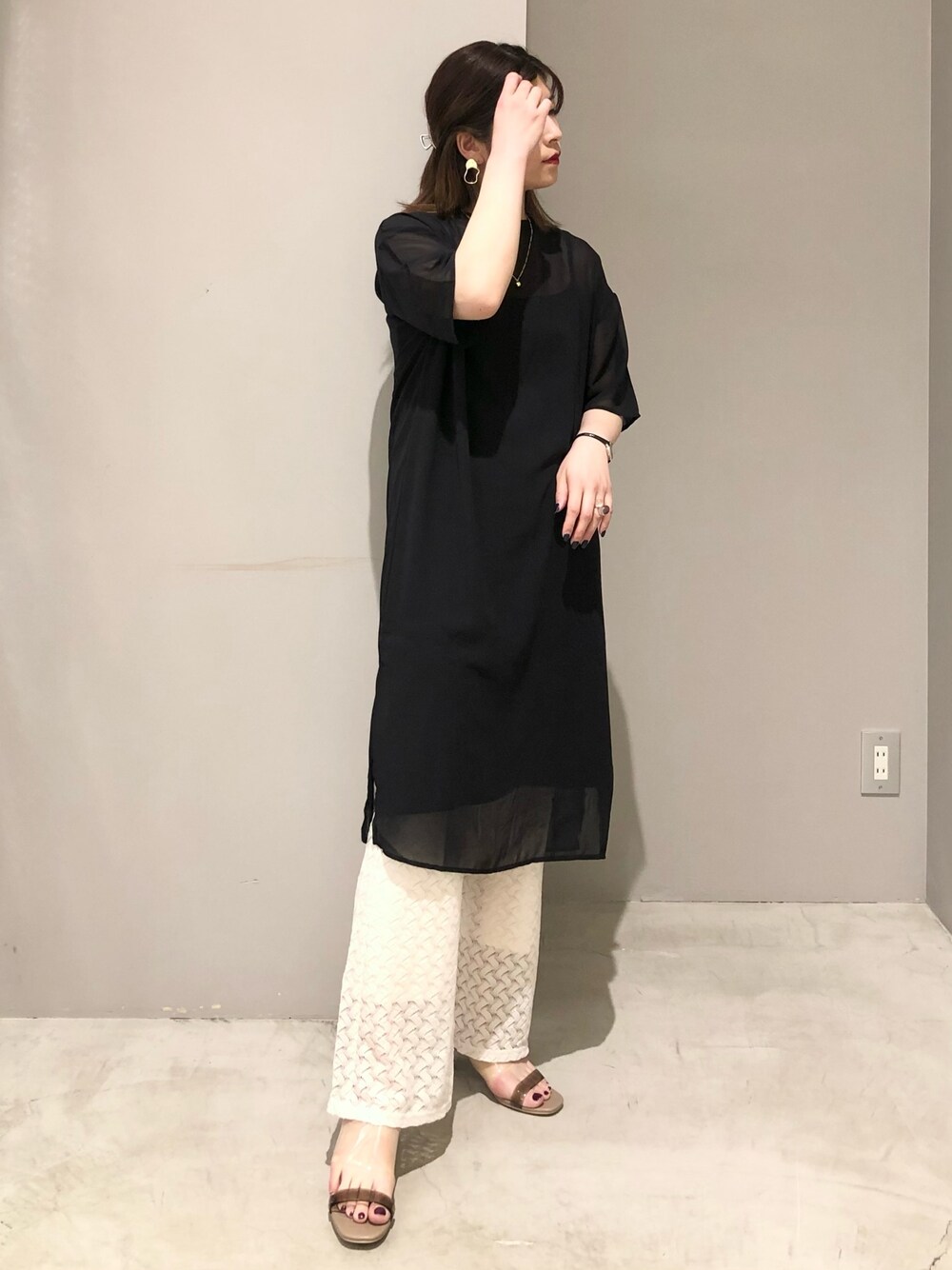 ブラック系のワンピース、ホワイト系のその他パンツ、ベージュ系のサンダルを着用したレディースの夏コーディネートの2枚目の写真