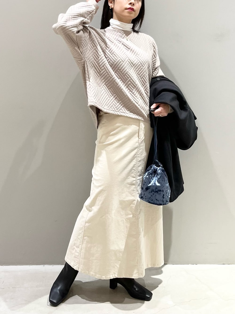 ベージュ系のTシャツ/カットソー、グリーン系のトップス、ブルー系のショルダーバッグを着用したレディースの冬コーディネートの1枚目の写真