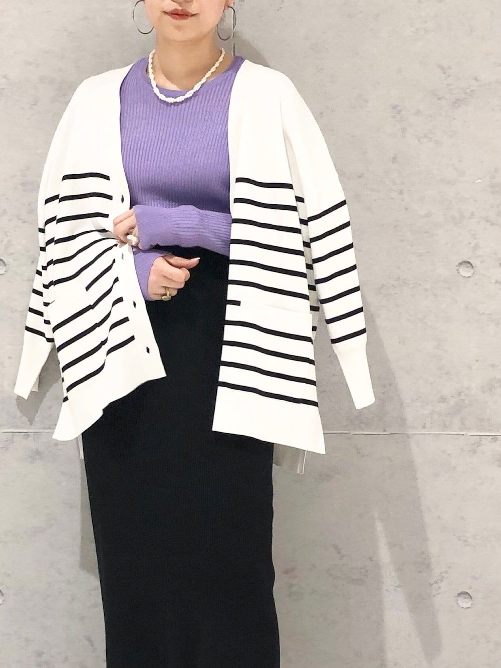 ブラック系のスカート、ホワイト系のブーツ、ホワイト系のカーディガン/ボレロを着用したレディースの冬コーディネートの2枚目の写真